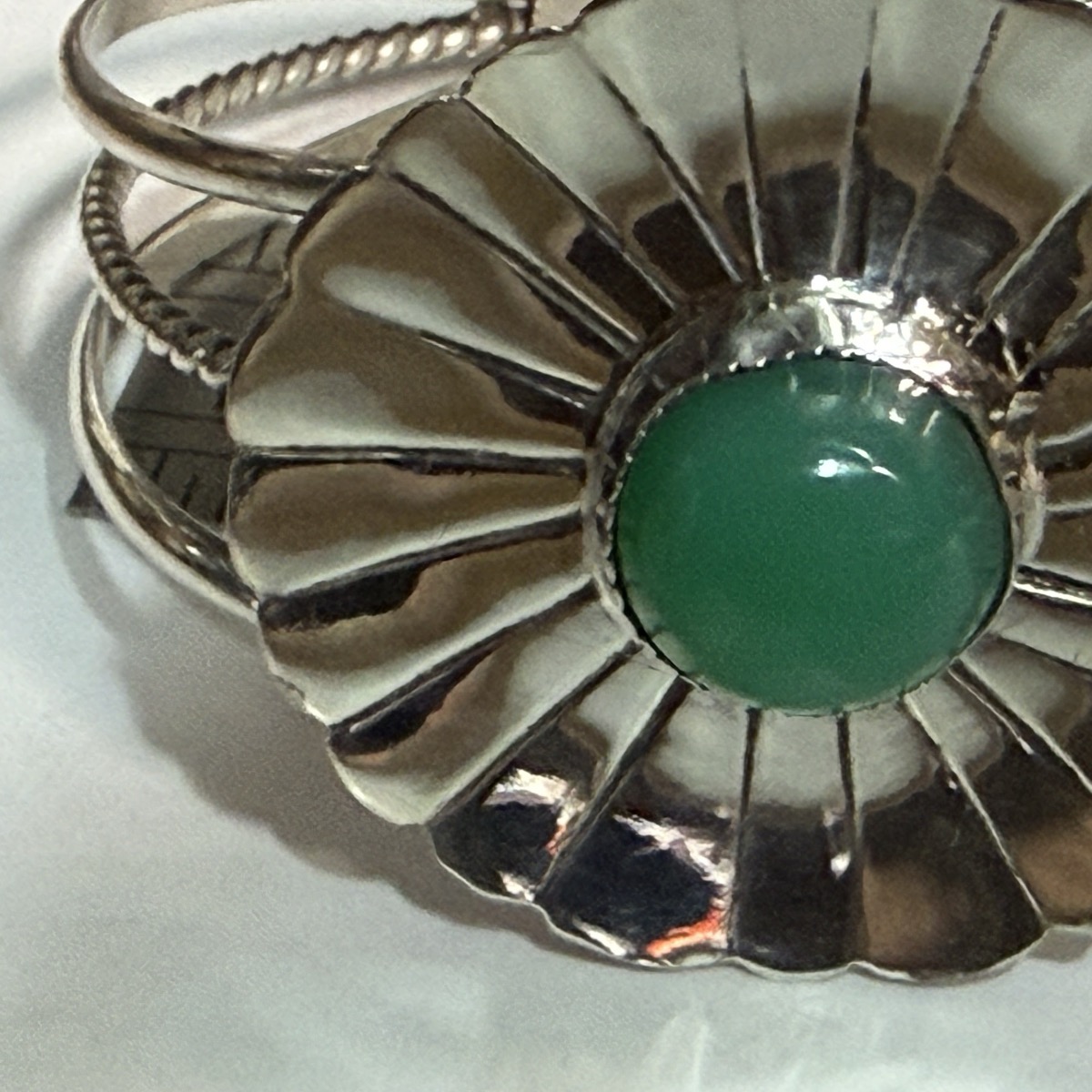 Fluted sterling silver concha cuff bracelet set with a round green chrysoprase cabochon.