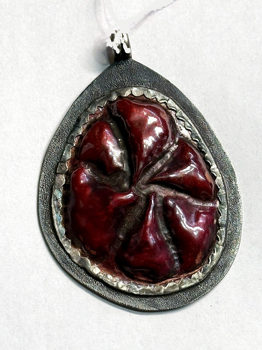 Hand-raised copper teardrop pendant with red heat patina in a sterling silver bezel.