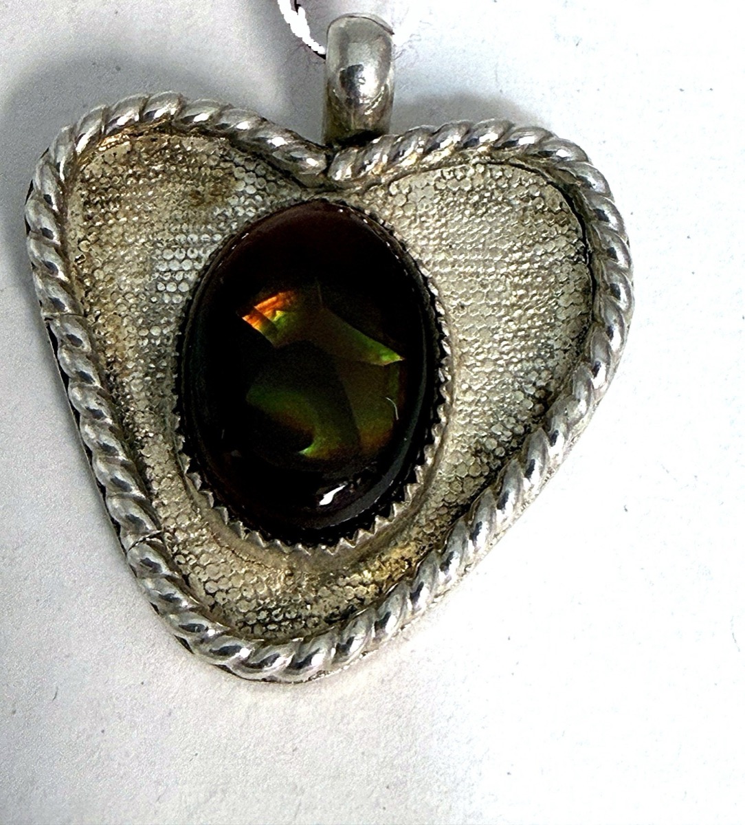 Reticulated sterling silver heart pendant set with a fire agate cabochon.