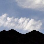 Dramatic mountain ridge silhouette against wispy high clouds, Death Valley
